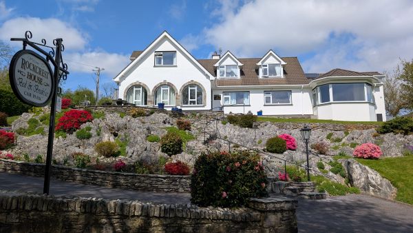 Rockcrest House exterior with rock gardens and flowering azaleas